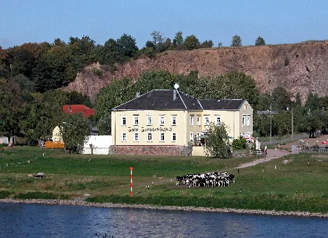 23.09.2009 01665 Kleinzadel (Zadel, Gemeinde Diera-Zehren): Blick von Zehren über die Elbe nach Zadel zum "Zum Zuessenhaus" (GMP: 51.195006,13.419016), Elbstraße 10. Die Sage zum Zuessenhaus / Als einst dieses Haus noch ein Wäldchen umgab / Vor vielen Jahren, als schlichte Fährhütte. / Als der Elbstrom noch raste beulend bergab / Über Steinblöcke, im wilden Bette / Trat hungrig und müde ein Jägersmann ein / Und bat um Speise und Trank. / Die Frau des Fährmanns, sie lud Ihn ein, / Auszuruhen auf hölzerner Bank. /Er erzählte, dass er sich habe verirrt / Beim Verfolgen und Jagen nach Wild. / Am Guckefelsen befragte er eine Hirt', / Welcher Ihn hierher habe geschickt. / Man brachte Ihm Butter. Käse und Brot, / Dazu noch ein großes Glas Milch. / Auch Eier und Schinken, er ward wieder froh / Und aß sich nun satt recht gemütlich. / Dann sprach er: Ihr Leute der Gastfreundlichkeit, / lch bin der Kurfürst von Sachsen. / Ihr dürft nun von heute ab jederzeit Solange die Elbe hier fließt vorbei / Bier schenken und Speise verkaufen / An Leute, die Stärkung gebrauchen. / Das Recht spreche ich euch für immer jetzt aus, / Euer Haus heißt nun künftig "Zum Zuessenhaus". [DSCN39207.TIF]20090923290DR.JPG(c)Blobelt