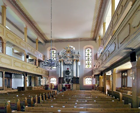 20.04.2015 04720 Rüsseina (Mochau -> Nossen), Kirchgasse: Dorfkirche Rüsseina (GMP: 51.110711,13.261834). Bereits 1090 wird Rocina als Pfründe des Doms zu Meißen erwähnt. Der Kirchturm, aus dem Mittelalter stammend, ist einer der ältesten der Umgebung. Das Kirchenschiff wurde erst 1786 fertiggestellt. Es ersetzte ein kleineres Kirchenschiff, das an der Westseite des Turmes angebaut war. Mit dem heutigen Kirchenschiff ist die Kirche eine der größten Dorfkirchen Sachsens (ca. 1300 Sitzplätze). 1885/86 wurde der Innenraum leicht umgestaltet und mit Holzimitationsmalerei versehen. Mit dem eindrucksvollen Kanzelaltar, den doppelten Emporen und der Orgel ergibt sich eine imposante Innenraumgestaltung. 1785 baute man eine Orgel der Lommatzscher Firma Richter für 900 Taler ein. Diese war jedoch mit Mängeln behaftet, so dass sie 1871 gegen eine neue Orgel der Firma Jehmlich aus Dresden ersetzt wurde. 2005 wurde sie generalüberholt. [SAM0012.JPG]20150420810DR.JPG(c)Blobelt