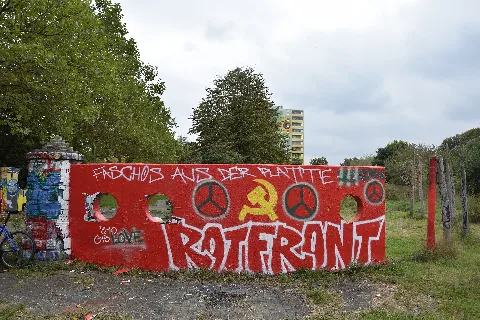 Antifa-Graffiti in Berlin (Marzahn-Hellersdorf) im Zusammenhang mit den Naziaufmarsch (III. Weg) am 03. Oktober 2020 in Berlin-Hohenschönhausen. Auf der Selben Wand und Seite hat Jemand Anfang des Jahres 2025 ein eher gegenteiliges Wandbild gesprüht mit dem grünen Schriftzug 'DER DRiTTE WEG', weiß umrahmt auf grünem Hintergrund. Diese Wand steht in der Zossener Straße, auf einer Grünanlage mit großem Spielplatz, zwischen den Sonnenblumen-Punkthäusern Nr. 68 und 66 (voraus zu sehen) und der Gleichrichterstation der BVG, Nr. 50 (gleich im Rücken des Betrachters), am nördlichen Zugang des Geländes. Auf dem Gelände stehen mehrere solcher ursprünglich Zierwände, welche auch ständig / viel von Graffiti Artisten genutzt werden.