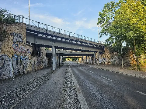 Bahnbrücken der S-Bahn über der Klemkestraße in Berlin-Reinickendorf, Deutschland. Links neben dem Bildausschnitt trennt sich die Kremmener Bahn von der Nordbahn. Die S25 fährt ab hier weiter Richtung Tegel und Hennigsdorf, die S1 und die S85 nach Wittenau und Oranienburg. Beide Bahnstrecken haben auf Höhe der Klemkestraße bereits eigene Gleise, weshalb gleich mehrere Bahnbrücken die Straße überqueren. Neben den Bahngleisen verlief bis 1989 die Berliner Mauer. Der Betrachter blickt aus dem Westteil in den ehemaligen Osten nach Berlin-Niederschönhausen im Bezirk Pankow.