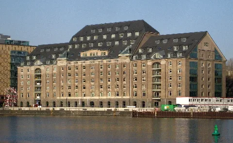 The former granary of Osthafen harbor on Stralauer Allee in Berlin-Friedrichshain, here seen from the Kreuzberg riverside of the Spree. It was built during the construction of the harbor (1907-1911) to a design by Friedrich Krause. In 2001/2001, it was renovated and rebuilt to house offices and lofts. The buildings has been designated as a historic landmark.