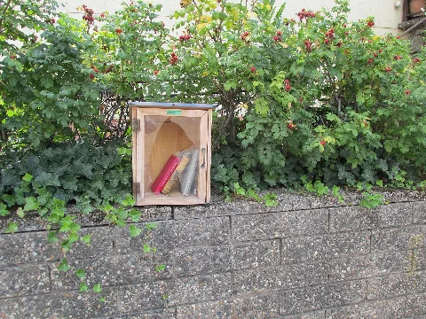 ein privates Bücherschränkchen auf der Gartenmauer des Hauses Leihgesterner Straße 1a in Linden-Großen-Linden