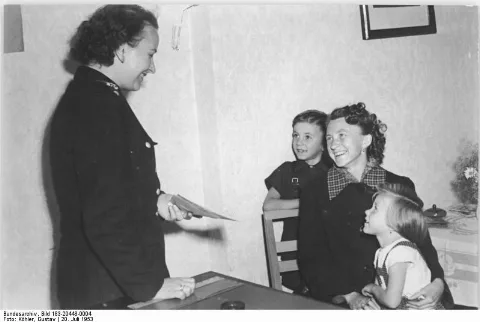 For documentary purposes the German Federal Archive often retained the original image captions, which may be erroneous, biased, obsolete or politically extreme. Zentralbild Köhler 20.7.1953 Interzonenpässe werden schnell ausgestellt Entsprechend den Beschlüssen der Regierung über die Erleichterung des Interzonenverkehrs werden alle Anträge von den Volkspolizei-Inspektionen schnell und unbürokratisch bearbeitet. Auf der Volkspolizei-Inspektion Berlin-Treptow, Johannisthal, Sterndamm. UBz: Frau Ilse Klappe, Hausfrau aus Adlerskof, erhält ihren Interzonenpass. Sie will mit ihren Kindern ihre Schwägerin in Bad Rothenfelde bei Osnabrück besuchen.