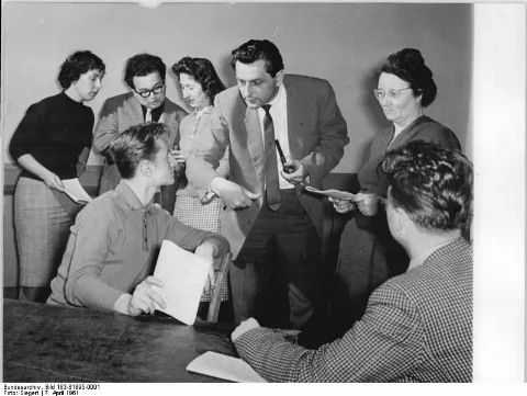 For documentary purposes the German Federal Archive often retained the original image captions, which may be erroneous, biased, obsolete or politically extreme. Gröditz, Mitglieder einer Laienspielgruppe Zentralbild Siegert 7.4.1961 Arbeitertheater des Stahl- und Walzwerkes Gröditz bereitet sich auf die III. Arbeiterfestspiele vor. Das Arbeitertheater des Stahl- und Walzwerkes Gröditz, das am 26. Januar 1961 gegründet wurde, studiert gegenwärtig für die III. Arbeiterfestspiele Brechts Stück "Die Gewehre der Frau Carrar" ein. Die Patenschaft über das Arbeitertheater haben Schauspieler der Landesbühnen Sachsen übernommen. UBz: Der Schauspieler Sepp Klose Dresden gibt den Kollegen vom Arbeitertheater Regieanweisungen.