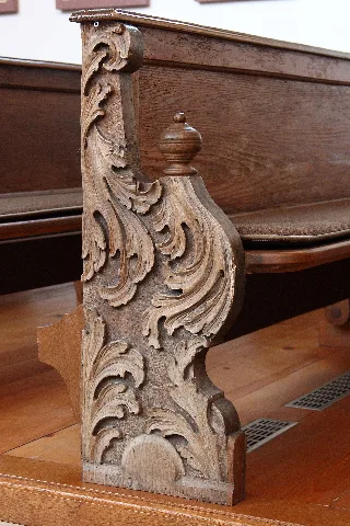 Kath. Filialkirche St. Vitus in Derndorf, Gemeinde Kirchheim in Schwaben. Geschweifte Eichenholzwange mit Akanthusschnitzerei am Laiengestühl von Anfang 18. Jh.