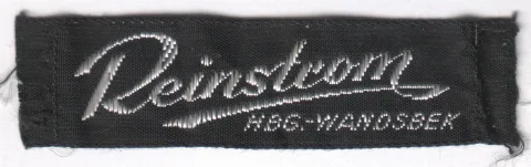 Firmen-Einnäh-Etikett des Kürschners Reinstrom aus Hamburg-Wandsbek (1,5 cm hoch). Lutz Reinstrom (* 29. März 1948 in Saßnitz) [Kürschner in Rahlstedt![1]] wurde 1992 in Hamburg als „Säurefassmörder“ bekannt. Er befindet sich seit 17. September 1991 ununterbrochen in Haft und wurde am 22. Mai 1996 vom Landgericht Hamburg wegen Mordes an zwei Frauen, versuchten schweren Raubes in Tateinheit mit Freiheitsberaubung sowie wegen erpresserischen Menschenraubes zu lebenslanger Freiheitsstrafe mit anschließender Sicherungsverwahrung verurteilt. Er verbüßt diese Strafe in einer Hamburger Justizvollzugsanstalt höchster Sicherheitsstufe.Wikipedia.de ↑ www.abendblatt.de Nr. 10 vom 12. Januar 1995, S. 9
