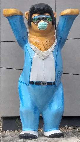 This buddy bear appears to be Elvis and was found in the Wuhlheide park in Berlin-Köpenick. Someone has attached a real surgical mask to the bear. As the strings don't reach to his ears, they are somehow stuck under the glasses.