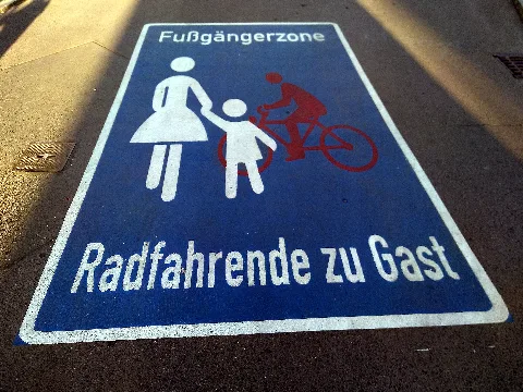 Roadway pictogram "Pedestrian zone – Cyclists as guests" in the pedestrian zone in Waldemarstraße in Berlin-Kreuzberg, Germany.
