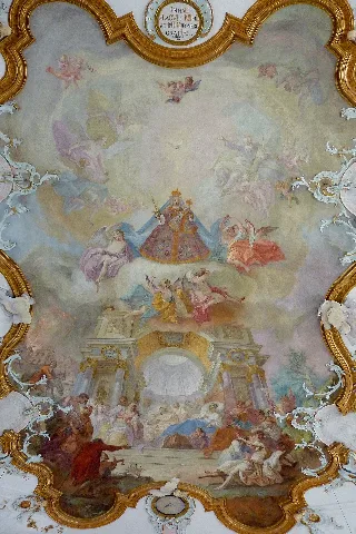 Katholische Pfarr- und Wallfahrtskirche Mariä Heimsuchung in Gottmannshofen, einem Stadtteil von Wertingen im Landkreis Dillingen an der Donau (Bayern), Deckenfresko von Johann Baptist Enderle (1725–1798), Stuck von Franz Xaver Feuchtmayer d. Älteren (1698–1763). Darstellung: Maria als Himmelskönigin, die ihren Schutzmantel ausbreitet über Bettler und Kranke, die sich unter einem monumentalen Triumpfbogen versammeln. Signatur: „Enderle pinxit“ (Enderle hat es gemalt). Zwischen dem Deckenfresko des Langhauses und dem Fresko über der Orgelempore befindet sich ein Chronogramm mit der Inschrift: „In haC pLaCVIt MIhI et tIbI DIsponere GratIas“ (An diesem Ort ha es mir und dir gefallen, Gnaden zu verteilen). Die Großbuchstaben entsprechen römischen Ziffern und ergeben die Jahreszahl 1763 (MDCCLVIIIIIIII), das Jahr, in dem die Fresken geschaffen wurden.