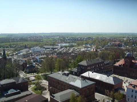 Blick von der Aussichtsplattform (auf 60 m Höhe) des Turms des Greifswalder Doms St. Nikolai nach Südwesten auf Fleischervorstadt und Fettenvorstadt. In der Mitte der Teich auf der Fleischerwiese, unten links das Institut für Deutsche Philologie, unten mittig die Alte Universitätsbibliothek, unten rechts mit Innenhof der alte Campus mit der Sternwarte im ehem. Institut für Physik.
