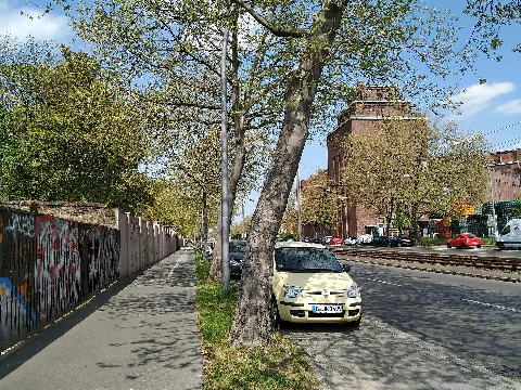 Indira-Gandhi-Straße in Berlin-Alt-Hohenschönhausen. Links steht die Friedhofsmauer des Jüdischen Friedhofes Berlin-Weißensee. Rechts steht die Berliner-Kindl-Schultheiss-Brauerei