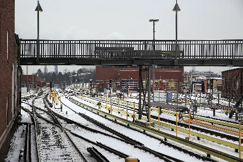 Vom Bansteigende Richtung Norden, im Bild hinter dem Brückensteg das neue Stellwerksgebäude mit zusätzlichen Fahrzeugständen im Untergeschoss. Die doppelte Kreuzungsweiche entspricht der neuesten Bauform mit elastischer Backenschienenverspannung ohne Stützwinkel.