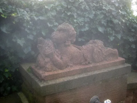 Burgbrünnele mit Brunnenfigur von de:Josef Zeitler, am Ende des Rennweges in Stuttgart-Wangen an der Stelle der ehemaligen de:Burg Hedelfingen. Konkav geschwungene Mauer mit quaderförmigem Brunnenstock und halbkugelförmigem Brunnentrog, Bekrönung des Brunnenstocks ist eine liegende Flötenspielerputte mit Bocksbeinen. Standort: siehe File:Stuttgart-Wangen, 0001.jpg.