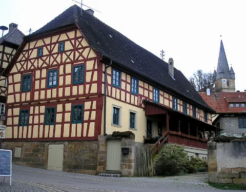 Mürsbach (Markt Rattelsdorf, Landkreis Bamberg, Upper Franconia, Germany). Timber frame building at the central place with the tower of the parish church St. Sebastian