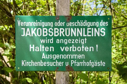 Puch bei Hallein (Bezirk Hallein): Schild beim Brunnen auf dem Kirchplatz im Ortsteil Sankt Jakob am Thurn
