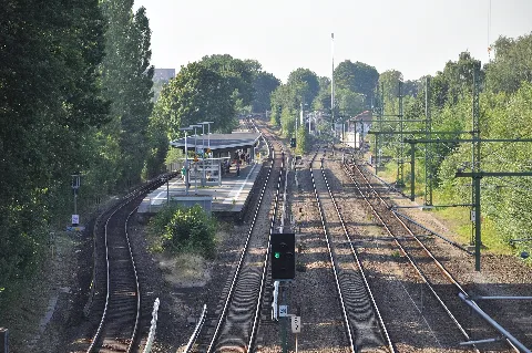 Blick von der Jahnbrücke auf der Grenze zwischen Hamburg-Barmbek-Nord und Hamburg-Winterhude Richtung Süden auf die Gleise der Güterumgehungsbahn (rechts) und der S-Bahn-Linie 1 (links) mit der S-Bahnstation Alte Wöhr. Im Hintergrund ist das Überwerfungsbauwerk zu erkennen, das die S-Bahn über die Güterumgehungsbahn führt.