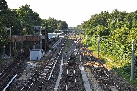 Blick von der Hebebrandbrücke auf der Grenze zwischen Hamburg-Barmbek-Nord und Hamburg-Winterhude Richtung Süden auf die Gleise der Güterumgehungsbahn (rechts) und der S-Bahn-Linie 1 (links) mit der S-Bahnstation Rübenkamp. In der Mitte befindet sich der Abzweig zum Betriebswerk Hamburg-Ohlsdorf der S-Bahn Hamburg bzw. zum Lagerbahnhof der Hamburger Hochbahn. Dieses Gleis verbindet das Netz der Hochbahn mit dem Fernbahn.