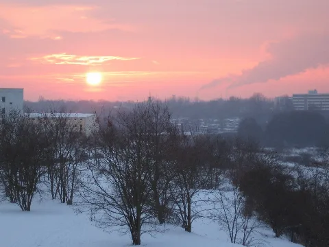 Berlin-Hellersdorf. Schnee, Sonnenuntergang und rosaroter Himmel. Blick aus der Nähe des Kummerower Rings, oberhalb des Regenrückhaltebeckens (RHB) Cecilienstraße, in das Wuhletal. Links am Bildrand sind die Gebäude der Feuerwache Hellersdorf zu sehen. Am rechten Bildrand ist auf Horizonthöhe das 'Seniorenheim Haus am Auwald', Buckower Ring 62, in Biesdorf zu erkennen. Der hier in den GEO-Daten angegebene Kamerastandort ist falsch. Er verweist auf einen Standort auf dem Hügel des Jelena-Šantić-Friedenspark. Der tatsächliche Standort müsste ca. bei 52.526415, 13.582560 liegen.