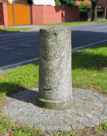 Milestone „XII Miles to Berlin“ („XII Meilen bis Berlin“) at Cottbus Street (Cottbuser Straße) in Lübben-Steinkirchen, Landkreis Dahme-Spreewald, Brandenburg, Germany. The milestone is a listed cultural heritage monument.