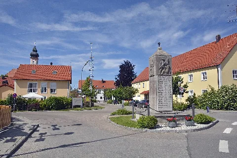 War Memorial in Vierkirchen (Upper Bavaria) - in the background Pfarrkirche St. Jakobus and Town Hall