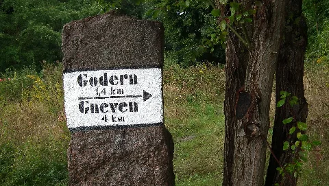 Wikipedia: Liste der Baudenkmale in Pinnow (bei Schwerin) - Mecklenburg-Vorpommern, Landkreis Ludwigslust-Parchim, Amt Crivitz, Godern, Nr. 17, L Abzweig nach Godern, Wegweiserstein. Der ursprüngliche Wegweiserstein ist mit einer weißen, schwarz umrandeten Binde mit moderner Schablonenschrift und einer Kilometerangabe versehen. Wann diese Beschriftung aufgetragen wurde, ist hier nicht bekannt. Dieser Wegweiserstein ist ein Beispiel dafür, dass die alten Steine eine neue Aufmerksamkeit finden.