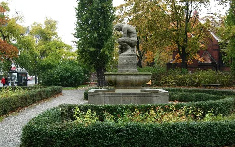Ernst Wenck: Geldzählerbrunnen (1912) auf dem Pappelplatz an der Invalidenstraße in Berlin-Mitte; links im Bild die Invalidenstraße, rechts die Kapelle (1898) des Friedhofs II der Sophiengemeinde; der Pappelplatz war im 19. Jahrhundert als Marktplatz genutzt worden, daher das monetäre Motiv des Brunnens; ihm schräg gegenüber (im Häusereck Acker- und Invalidenstraße) steht die Ackerhalle (errichtet als Markthalle VI in den Jahren 1886 – 1888 nach Entwürfen von Hermann Blankenstein)
