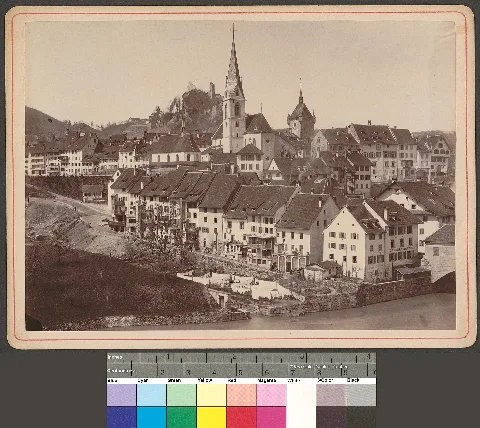 Baden. Beide Kirchen und Schloss: Blick von Ennetbaden nach Westen auf die Stadtpfarrkirche Maria Himmelfahrt, Stadtturm und Ruine Stein, ganz rechts ein Teil der Holzbrücke, Wohnhäuser mit Wäscheleine